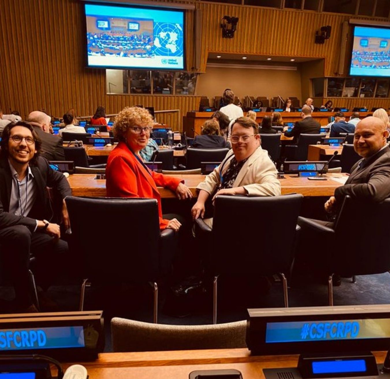 Jonathan Boulet-Groulx (L'Arche Internationale), Lori Vaanholt, Nick Herd et Warren Pot (tous de L'Arche Canada) regardant derrière eux la caméra alors qu'ils étaient assis à la Conférence des États parties (COSP) 2023 à l'ONU à New York